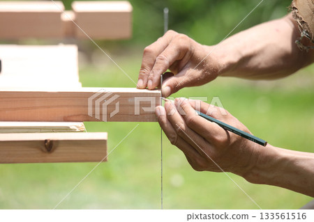 一名男子在木材上做標記 133561516