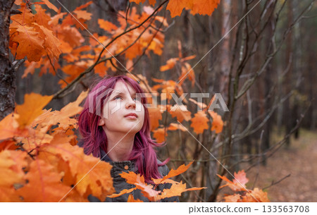 Young girl with pink hair looking up in autumn forest Young girl with pink hair looking up in autumn forest 133563708