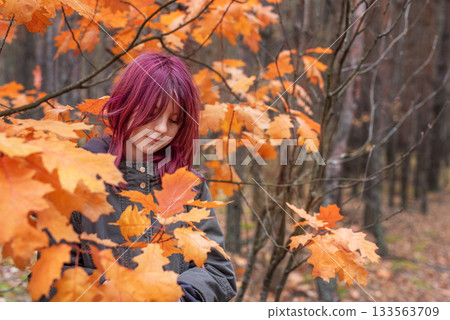 Teenage girl enjoying autumn day in forest 133563709