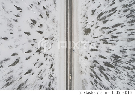 Aerial view of the highway against the backdrop of a winter forest, top dawn 133564016