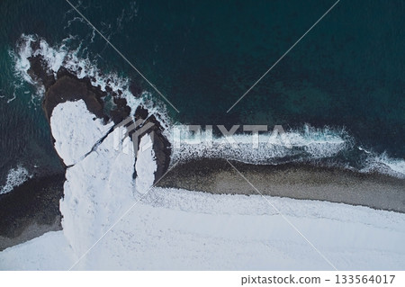 Aerial view of the coast and the freezing Barents Sea on the Kola Peninsula in winter, close-up view down Aerial view of the coast and the freezing Barents Sea on the Kola Peninsula in winter, close-up view down 133564017