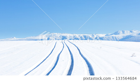 冬日北海道美瑛山區的公路，藍天白雲，積雪壓實的路面上留有汽車的痕跡。 133564684