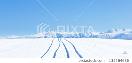 A road in the hills of Biei, Hokkaido in winter, with blue skies and traces of cars on a packed snow road A road in the hills of Biei, Hokkaido in winter, with blue skies and traces of cars on a packed snow road 133564686