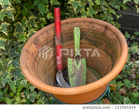 A sickle and shovel in a large garden 133565834