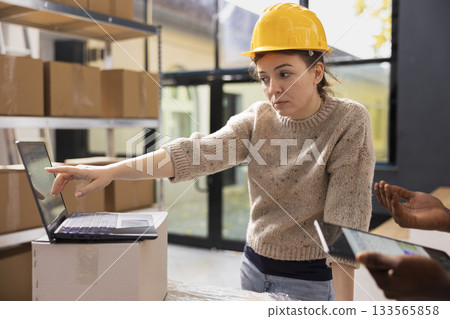Staff members ensuring accurate order processing on a laptop, checking stock inventory in a small scale depot. Supporting e-business services with retail shipment and in house quality control. Staff members ensuring accurate order processing on a laptop, checking stock inventory in a small scale depot. Supporting e-business services with retail shipment and in house quality control. 133565858
