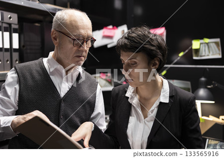 Law enforcement agents connecting clues on a mystery board, analyzing case files and confidential information during a clandestine operation to expose organized crime. Incident room. Law enforcement agents connecting clues on a mystery board, analyzing case files and confidential information during a clandestine operation to expose organized crime. Incident room. 133565916