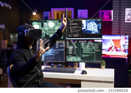 Hacker installing spyware using virtual reality tech and AI to secretly gather data about user activity. Rogue developer coding exploits using VR headset to gain unauthorized access 133566030