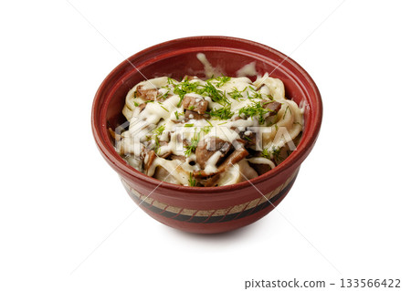 Delicious pasta dish served in a rustic bowl topped with herbs and creamy sauce 133566422