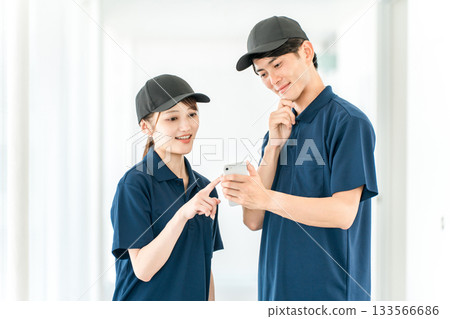 Cleaning workers in polo shirt uniforms, male and female building maintenance staff 133566686