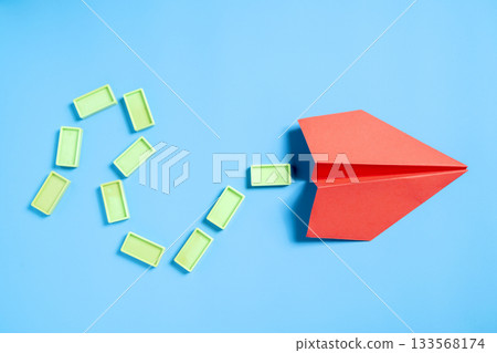 Red paper airplane with rectangular blocks on a blue background. Concept of travel, exploration, and navigation Red paper airplane with rectangular blocks on a blue background. Concept of travel, exploration, and navigation 133568174