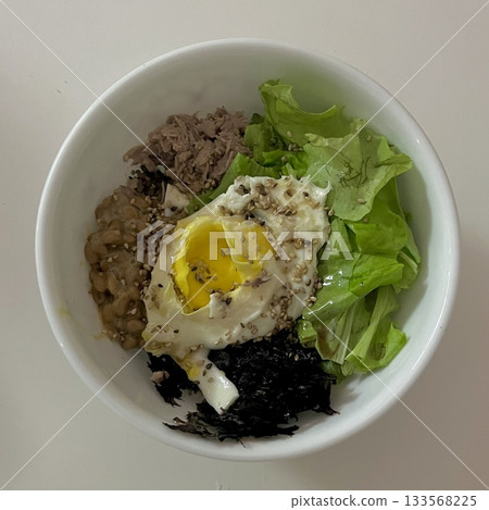 Bibimbap, a vibrant Korean rice dish topped with a variety of seasoned vegetables, gochujang, and a fried egg, often accompanied by sliced meat. Mixed together, it creates a flavorful and balanced. Bibimbap, a vibrant Korean rice dish topped with a variety of seasoned vegetables, gochujang, and a fried egg, often accompanied by sliced meat. Mixed together, it creates a flavorful and balanced. 133568225