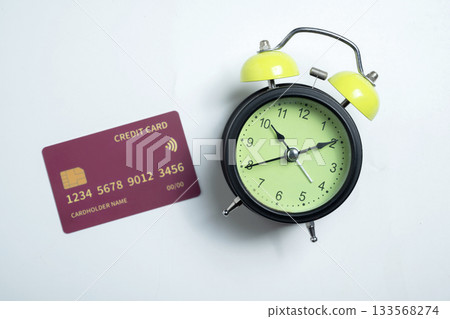 Credit card and alarm clock on a white background. Concept of finance, time management, and modern lifestyle 133568274