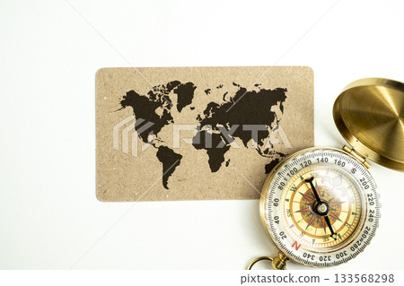 Antique compass with a card of a worldwide map on a white background. Concept of travel Antique compass with a card of a worldwide map on a white background. Concept of travel 133568298