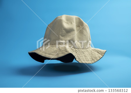 Beige cloth bucket hat on a blue background. Concept of travel, summer, or vacation 133568312