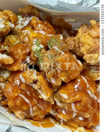 Crispy Korean fried chicken, perfectly glazed with a sweet and spicy sauce. Ideal for food photography and menus, showcasing the irresistible crunch and flavor of this beloved dish. Crispy Korean fried chicken, perfectly glazed with a sweet and spicy sauce. Ideal for food photography and menus, showcasing the irresistible crunch and flavor of this beloved dish. 133568336