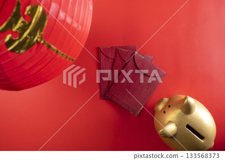 Red Chinese lantern with red envelopes or angpao and a piggy bank on a red background. Mockup, template, or copy space. Decoration for the Lunar or Chinese New Year celebration Red Chinese lantern with red envelopes or angpao and a piggy bank on a red background. Mockup, template, or copy space. Decoration for the Lunar or Chinese New Year celebration 133568373