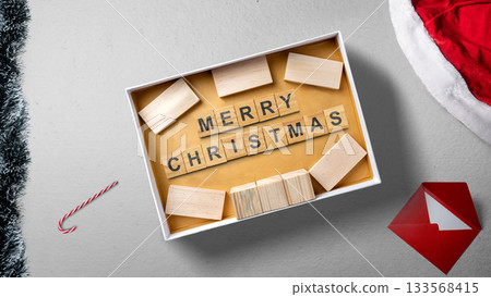 Greeting of Merry Christmas text with a wooden block in a gift box. Mockup or Copy space. Holiday greetings or winter themes. Concept of the Merry Christmas celebration 133568415