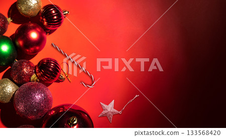 Christmas ornament decoration and a candy cane on a red background. Mockup or Copy space. Holiday greetings or winter themes. Concept of the Merry Christmas celebration Christmas ornament decoration and a candy cane on a red background. Mockup or Copy space. Holiday greetings or winter themes. Concept of the Merry Christmas celebration 133568420