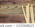 Many disposable chopsticks placed on a wood grain background 133568625