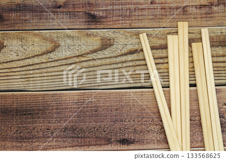 Many disposable chopsticks placed on a wood grain background 133568625
