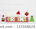 The word "CHRISTMAS" and Christmas decorations placed on a white wooden background 133568628