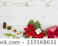 Poinsettia and presents at the bottom of a white wood background, and a bell garland at the top 133568631