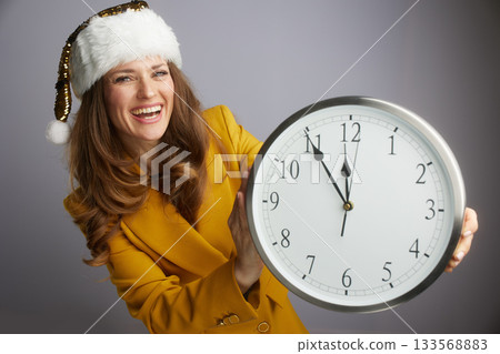 Festive Businesswoman Presenting New Year Clock 133568883