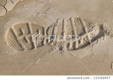 Footprint of a hiking boot creating a deep impression on the sand Footprint of a hiking boot creating a deep impression on the sand 133568957