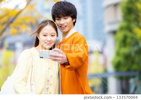 一對情侶在銀杏樹前自拍。 133570004