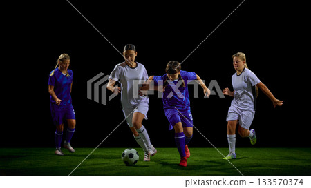 Teenage female soccer players competing for ball in dynamic midfield action Teenage female soccer players competing for ball in dynamic midfield action 133570374