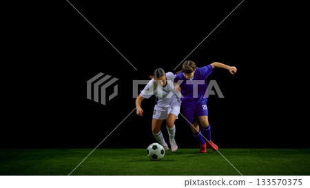 Female soccer players pushing shoulder to shoulder in chase for ball Female soccer players pushing shoulder to shoulder in chase for ball 133570375