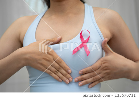 Breast cancer, pink ribbon at Asian senior lady for supporting awareness, symbol of World Breast Cancer Day. 133570731