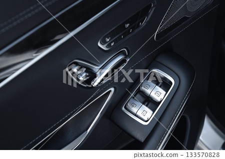 Detail of car door controls showing window switches and interior design features Detail of car door controls showing window switches and interior design features 133570828