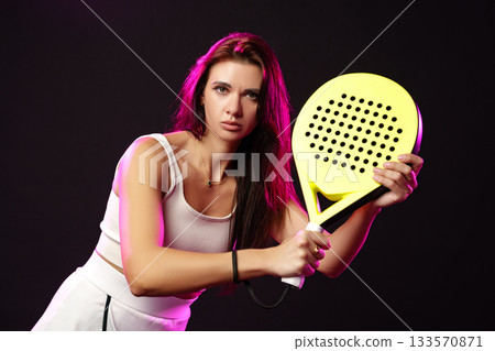 Young athlete preparing for a match with paddle racket in a studio setting 133570871