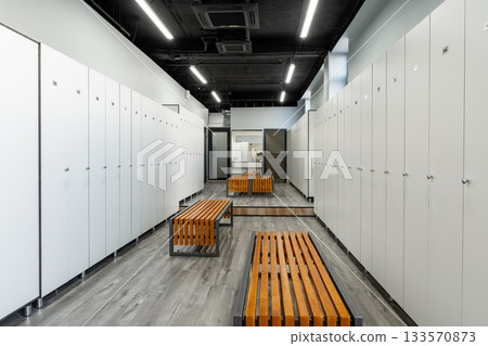 Modern locker room with wooden benches and sleek design in sports facility Modern locker room with wooden benches and sleek design in sports facility 133570873