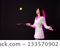 Young woman playing tennis while juggling a yellow ball on stage during a performance 133570902