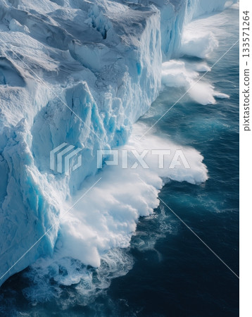 Glacier calving event creating a large splash as a massive ice chunk breaks off, highlighting the dynamic nature of polar ice caps and ongoing climate change 133571264