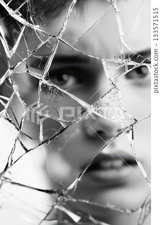 Woman's eyes looking through broken glass, her features distorted and fragmented, symbolizing concepts of emotional pain, vulnerability, mental illness, and a fractured self perception 133571515