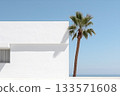 Minimalistic landscape with a white building and a palm tree against a blue sky 133571608