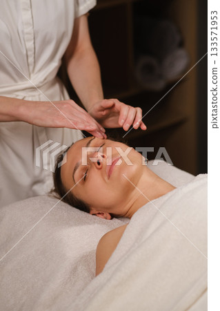 Relaxation and rejuvenation at a spa with a skilled facial treatment in a calm environment 133571953