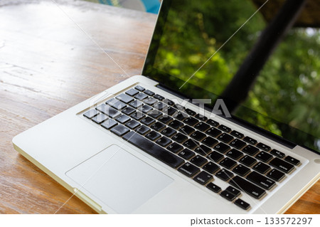 Outdoor Laptop On Wooden Table With Greenery Reflection For Modern Tech And Work In Bright Day Outdoor Laptop On Wooden Table With Greenery Reflection For Modern Tech And Work In Bright Day 133572297