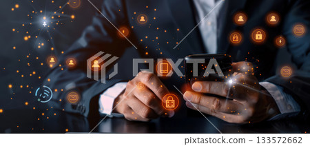 Businessman using smartphone with glowing security hologram 133572662