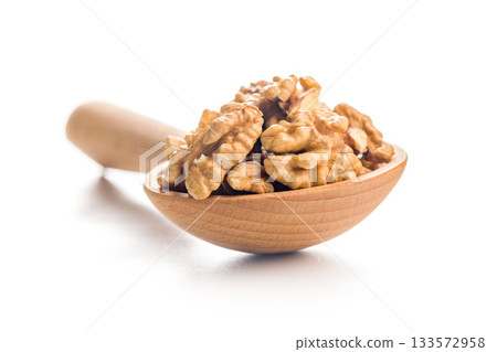 Peeled walnut kernels in wooden scoop isolated on white background. 133572958