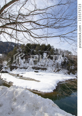 積雪覆蓋的河岸和翠綠的水面(垂直構圖) 積雪覆蓋的河岸和翠綠的水面(垂直構圖) 133573723