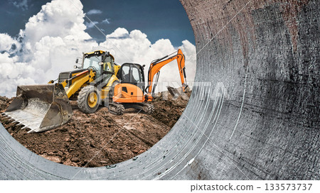 Heavy machinery is digging and moving dirt on a construction site under a cloudy sky, showing active work in progress 133573737