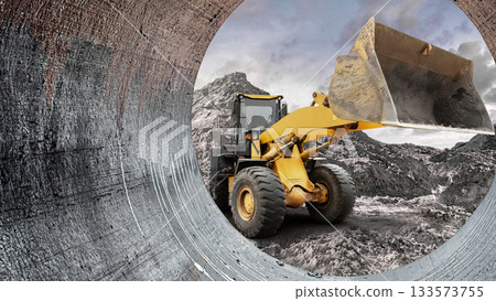 A yellow excavator is busy moving soil at a construction site surrounded by rocky terrain and cloudy skies, showcasing heavy machinery in action A yellow excavator is busy moving soil at a construction site surrounded by rocky terrain and cloudy skies, showcasing heavy machinery in action 133573755