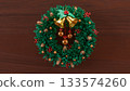 Christmas Wreath with Golden Bells on Wooden Background 3d render 133574260