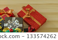 Christmas Gift Box with Golden Ribbon on Festive Table 3d render. 133574262