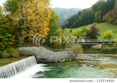 Beautiful European park with river and waterfall in autumn 133574489