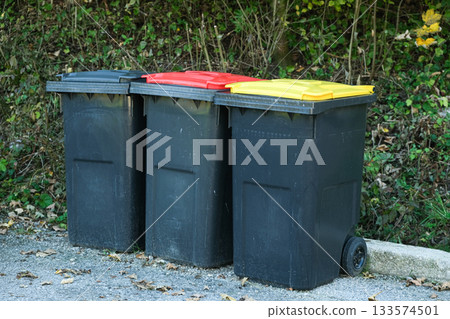 Garbage sorting in Europe. Garbage cans with colorful lids for different types of garbage Garbage sorting in Europe. Garbage cans with colorful lids for different types of garbage 133574501